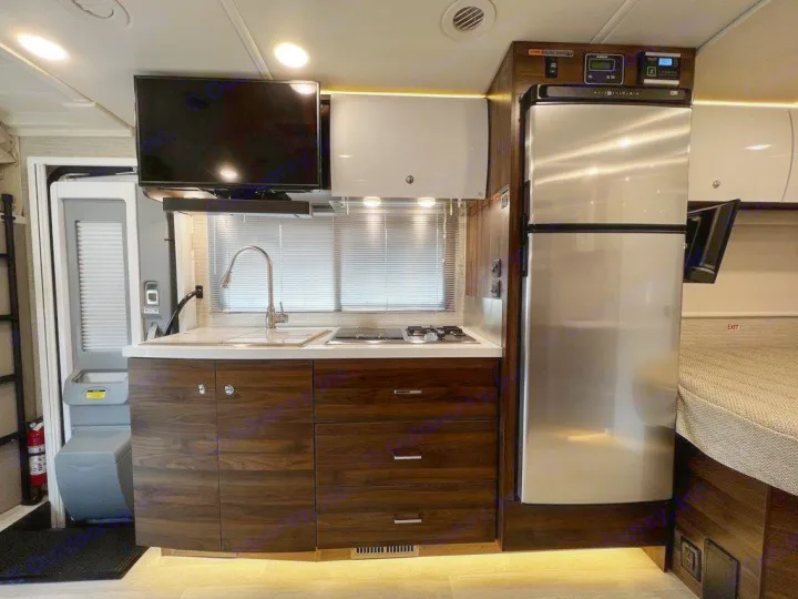 Discover this well-equipped RV rental kitchen: sink, stove, fridge, TV, and smart storage. Ready for adventure!. Winnebago Navion 2021