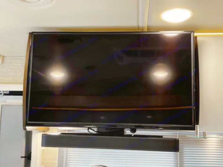Compact RV rental: wall-mounted TV with a soundbar, ready for entertainment on the road.. Winnebago Navion 2021