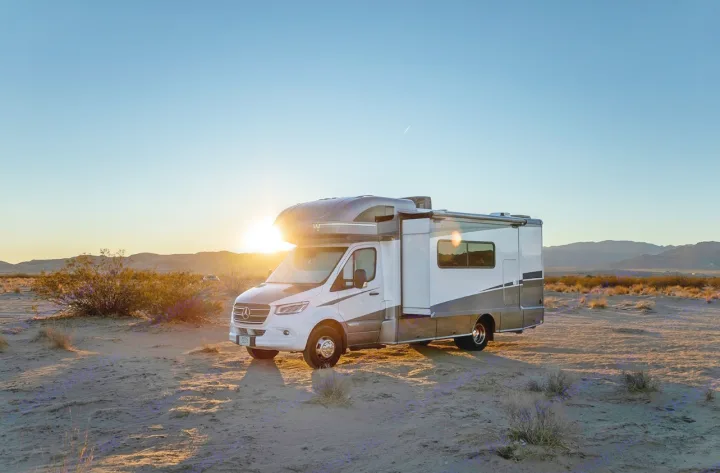 This modern white and gray rv rental is perfectly positioned in the desert at sunset, ready for your next adventure.. Winnebago View 2022