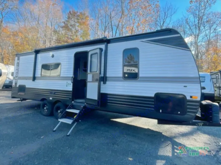 This grey Hideout travel trailer, perfect for an rv rental, is shown with its door open and steps extended.. Keystone RV Hideout 2022