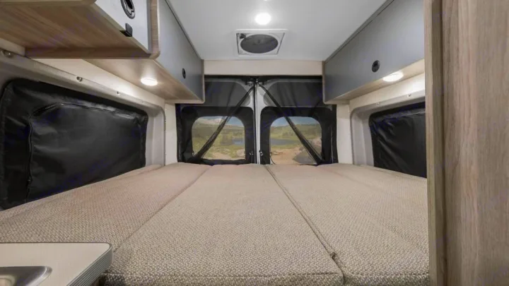 RV rental: Camper van interior with spacious bed & scenic rear view. Perfect for outdoor adventures.. Winnebago Solis 2021
