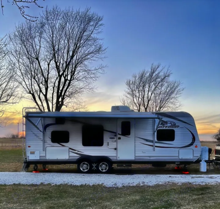 Serene outdoor camping with a Jay Flight travel trailer rv rental set up on gravel for an evening.. Jayco Jay Flight 2015