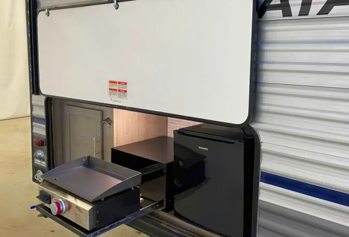 This RV rental has an outdoor kitchen with a Hotpoint mini-fridge and pull-out griddle for convenient outdoor cooking.. Forest River Coachmen Catalina Summit 2022
