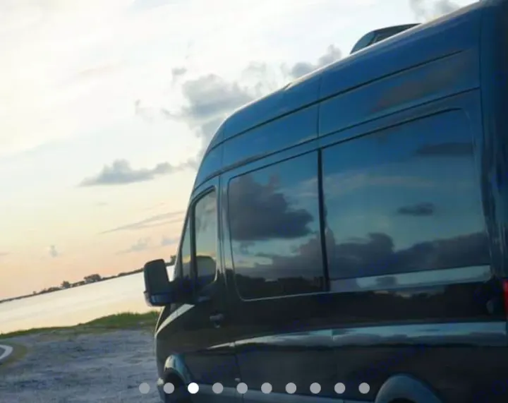 Scenic RV rental: Dark van by serene water at sunset, clouds reflecting in windows.. Mercedes Sprinter 2013