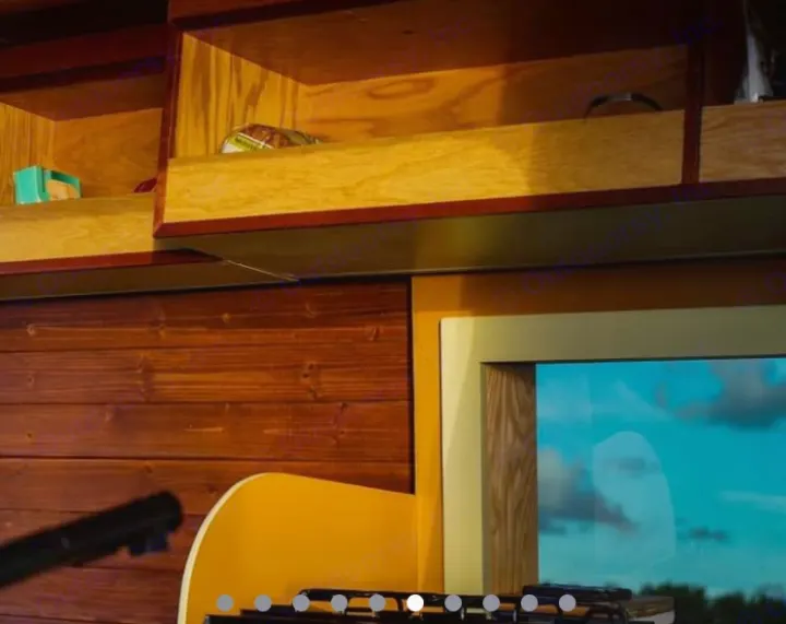 Cozy RV rental interior: wooden cubbies, a window revealing blue sky, and a guitar for travel tunes.. Mercedes Sprinter 2013