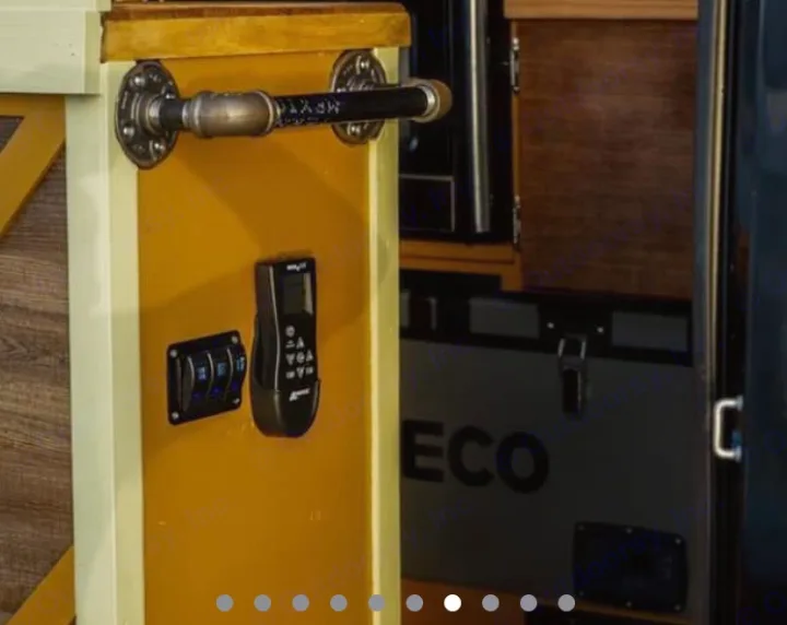 RV rental interior: Industrial grab bar, control panel with blue-lit switches, handheld remote, and an 'ECO' cooler.. Mercedes Sprinter 2013