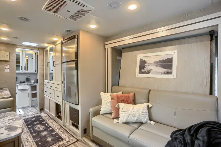 Spacious rv rental interior featuring a modern living area with couch, kitchen, and dining nook. Perfect for comfortable travel.. Thor Vegas 2022