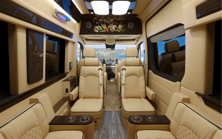 Luxury rv rental interior with plush cream leather seating, TV, wood floors, and scenic views. Enjoy premium travel comfort.. Ultimate Toys Ultimate Cruiser 2022
