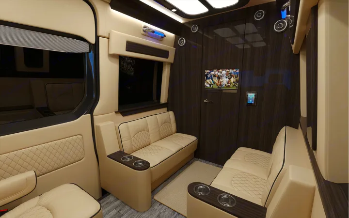 Luxury RV rental interior with plush beige seating, wood panels, TV & cup holders, perfect for comfortable travel.. Ultimate Toys Ultimate Cruiser 2022