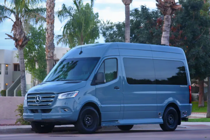 Light grey Mercedes-Benz Sprinter conversion van, ideal for rv rental. Parked curbside amidst palm trees.. Ultimate Toys Ultimate Cruiser 2022