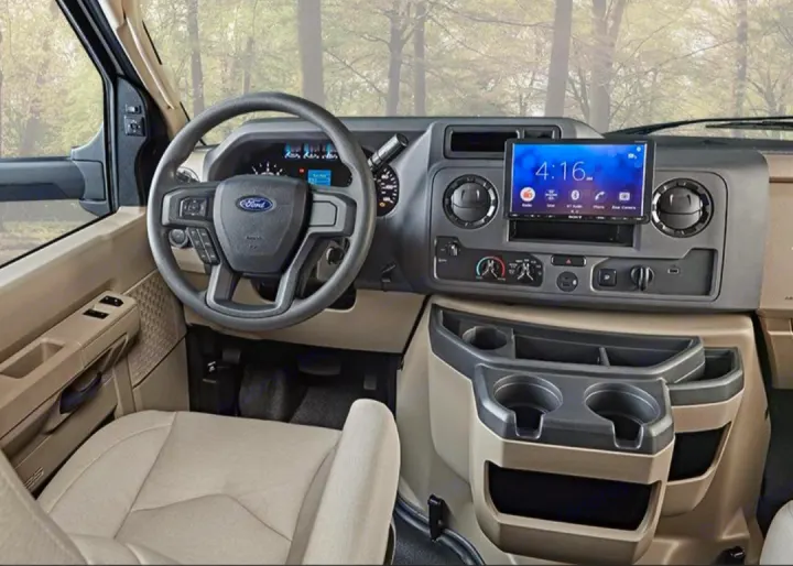 Spacious Ford van interior for RV rental: dashboard, steering wheel, modern infotainment, and cup holders.. Entegra Esteem 29v 2022
