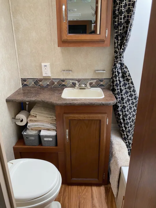 Compact RV rental bathroom with vanity, sink, toilet, and shower, offering practical comfort for travelers.. Forest River Salem 2015