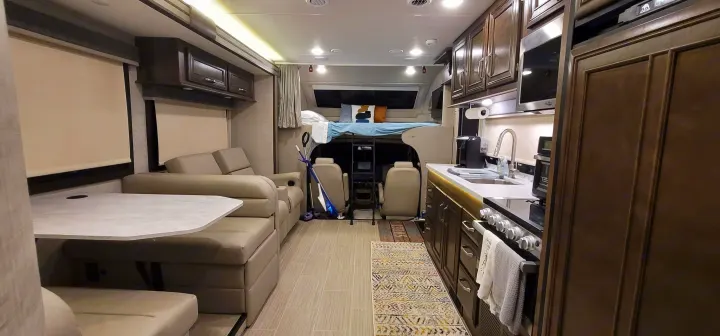 Spacious RV rental interior: cozy living area, full kitchen, and comfortable bunk bed. Ready for adventure!. Entegra Esteem 29v 2022