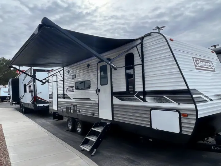 White Coleman travel trailer with extended awning and steps. Perfect for your next RV rental adventure.. Dutchmen Coleman Lantern LT 2022