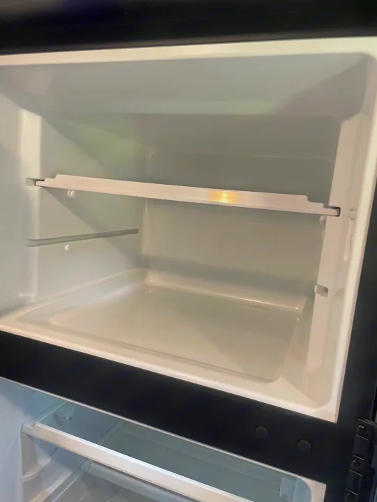 Empty compact refrigerator interior of an RV rental, ready for your essentials.. Dutchmen Aspen Trail 25 BH 2022