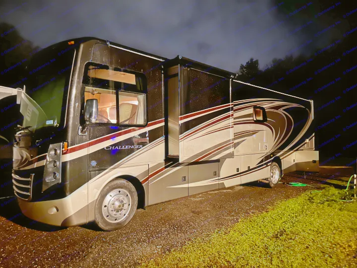 Thor Challenger motorhome parked at night, interior lights on. Ideal for an rv rental adventure or camping.. Thor Challenger 2015