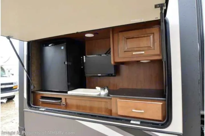 This RV rental features a convenient outdoor kitchen with a mini-fridge, TV, and sink for comfortable camping.. Heartland RVs Gateway 2015