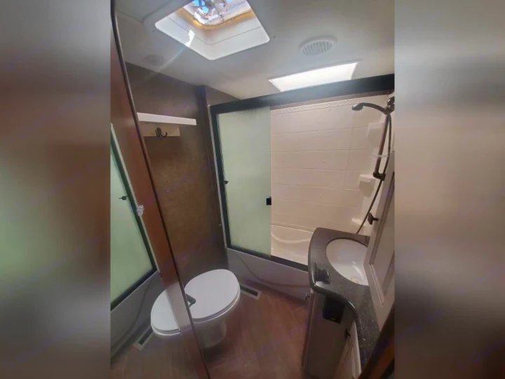 Inside an RV rental bathroom: functional design with shower, toilet, & sink for comfortable travel.. Heartland RVs Gateway 2015