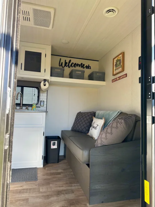 RV rental interior: A compact kitchen, comfortable couch, and warm decor create a welcoming living space.. Keystone RV Hideout 2022