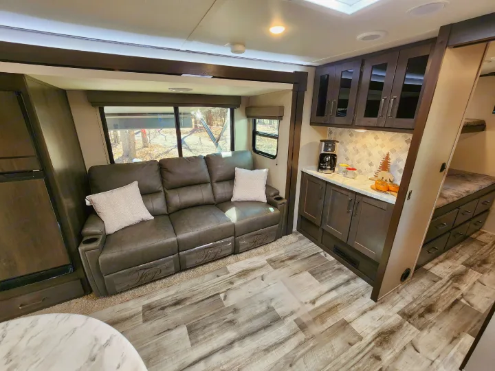 Spacious RV rental interior with comfortable recliners, a modern kitchen, and cozy bunk beds. Perfect for your next trip!. Grand Design Transend Xplor 315BH 2023