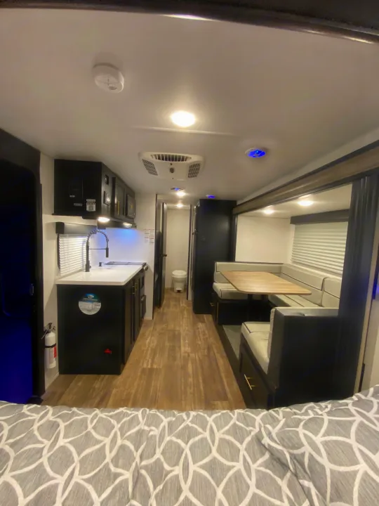 Explore this modern RV rental interior: a compact kitchen, comfortable dinette, and a cozy bedroom for your adventures.. Forest River Cherokee Wolf Pup 2022