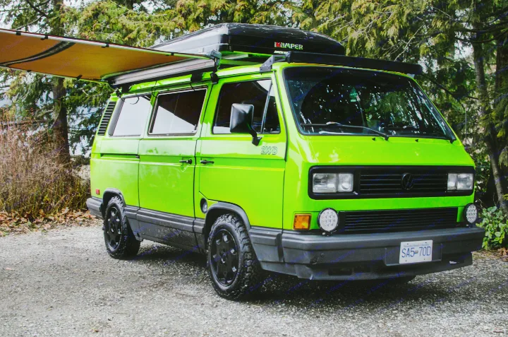 Bright green VW Vanagon RV rental with rooftop tent & awning, ready for off-road camping adventures.. Volkswagen Vanagon 1989