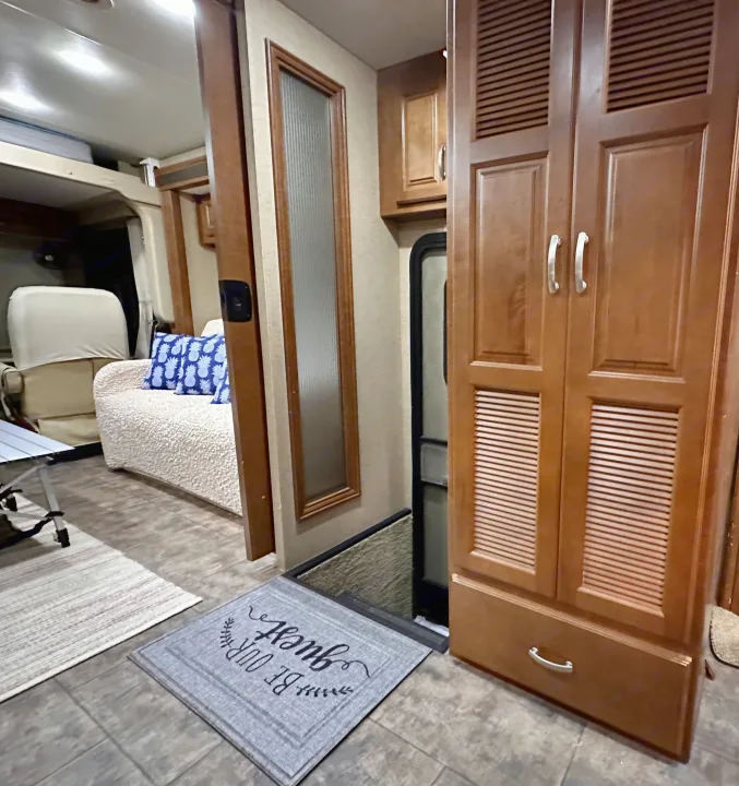 RV rental interior: a warm, inviting space with wood cabinets, an entry door, and a comfy living area. Ready for adventure.. Thor Challenger 2015