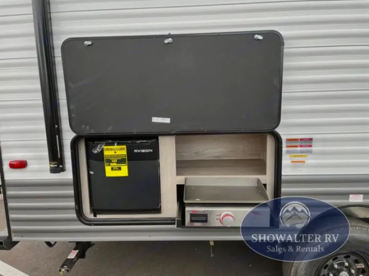 This RV rental outdoor kitchen features a mini-fridge and pull-out griddle, perfect for convenient camping trips.. KZ Sportsmen Classic 191BHK 2025