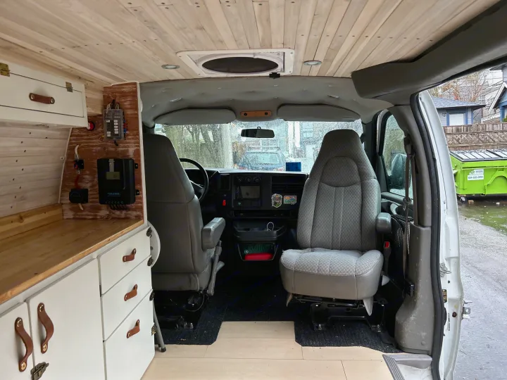 RV rental: Inside a converted van, featuring the cockpit, wooden ceiling, and a custom build with power controls & storage.. Chevrolet Express 2005