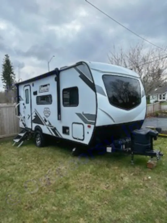 This white travel trailer RV on grass is ready for your next adventure. Find the perfect RV rental for camping!. Dutchmen Coleman Rubicon 2021