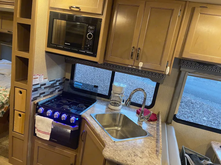 RV rental kitchen: This galley features a stove, microwave, sink, and coffee maker, providing all essentials for life on the road.. Thor Freedom Elite 2019