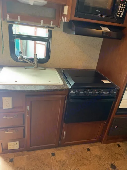 RV rental: Compact kitchen with microwave, stovetop, sink, and wood cabinets. Ready for your travel adventures!. Winnebago Other 2013