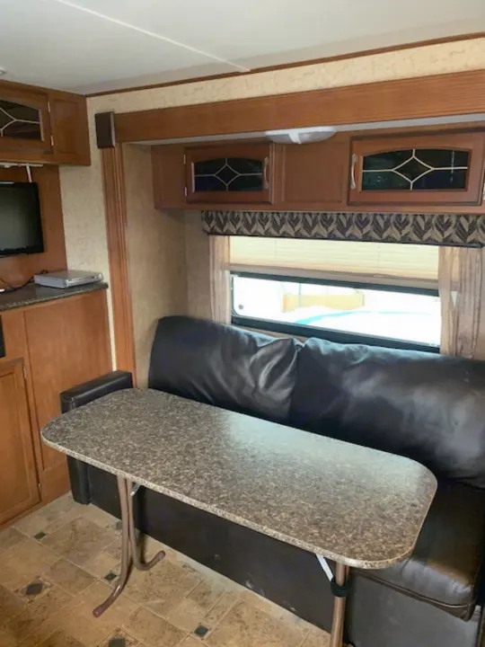 Spacious RV rental interior with dining table, comfy sofa, and wood cabinets. Perfect for your next trip!. Winnebago Other 2013