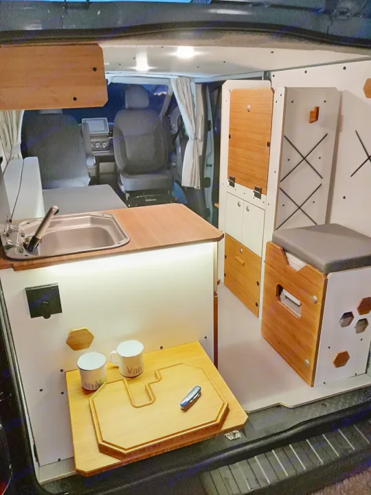 Modern camper van interior, perfect for your next rv rental. Features a compact kitchen, smart storage, and cozy living space.. Renault Trafic aménagé avec kit North West de VAN MANIA 2024