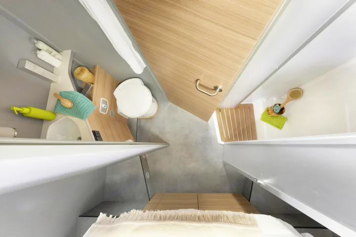 Overhead view of a modern RV rental washroom, featuring a compact shower, toilet, and sink area. Optimized for travel.. Dethleffs JUST T7052 DBM 2023