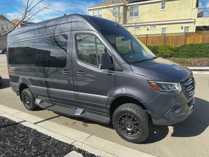 Dark grey Mercedes-Benz Sprinter van, equipped for rv rental. Features off-road tires for adventure travel.. Ultimate Toys Ultimate Cruiser 2021