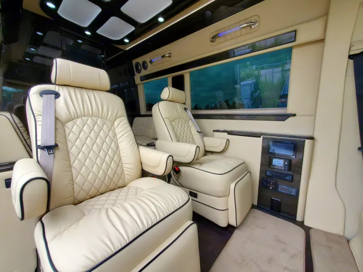 Luxury RV rental interior featuring plush captain's chairs, entertainment system, and spacious design with tinted windows.. Ultimate Toys Ultimate Cruiser 2021