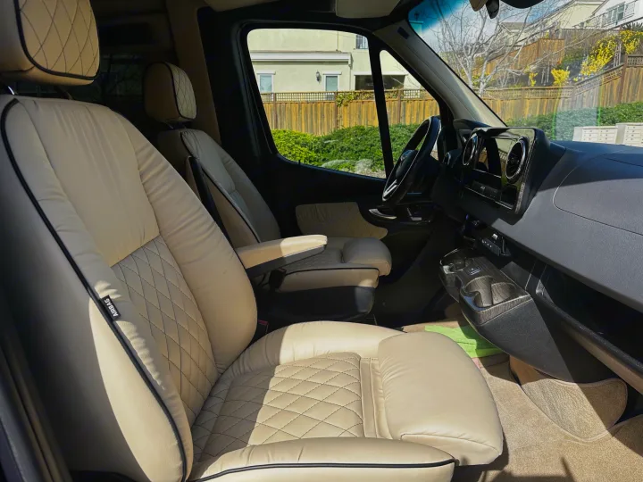 Step into luxury with this RV rental's spacious cockpit, featuring cream diamond-stitched leather seats.. Ultimate Toys Ultimate Cruiser 2021