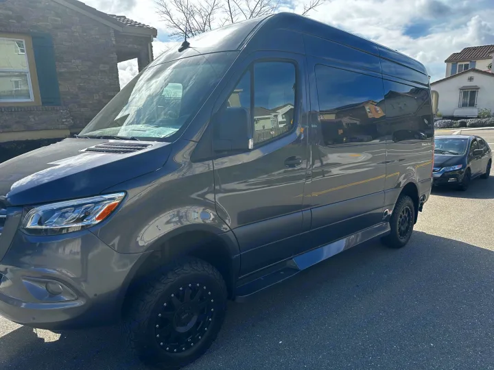 Dark grey Mercedes Sprinter van with custom wheels, ideal for rv rental adventures. Parked on a sunny street.. Ultimate Toys Ultimate Cruiser 2021