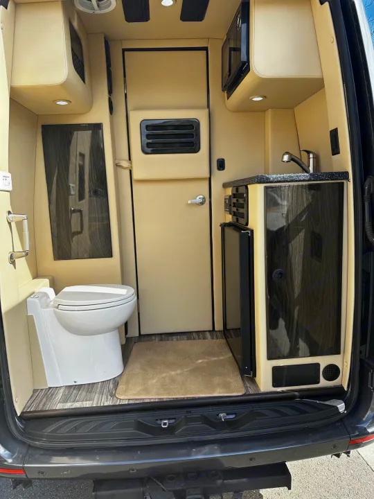 This RV rental shows a compact interior with a toilet, sink, microwave, & fridge, perfect for small living spaces.. Ultimate Toys Ultimate Cruiser 2021