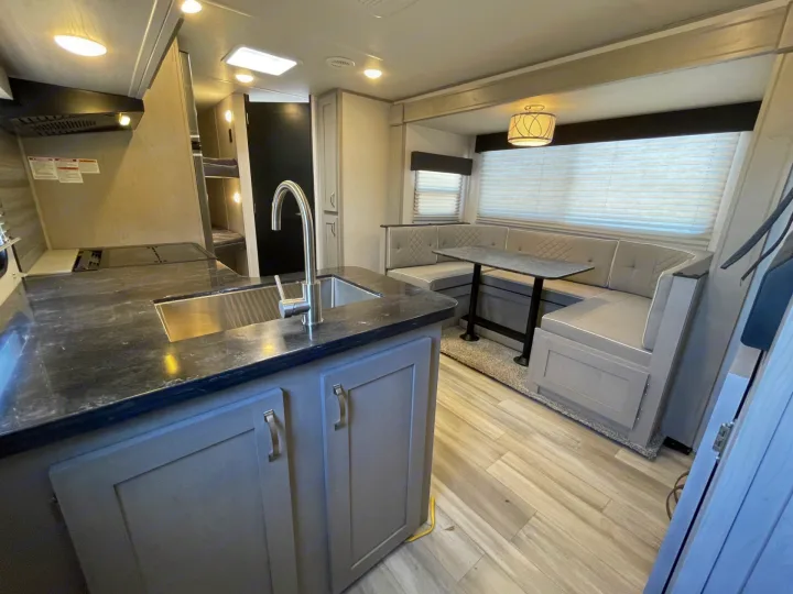 Modern RV rental interior: kitchen, cozy dinette, & bunk beds for family travel.. Forest River Tracer 2022