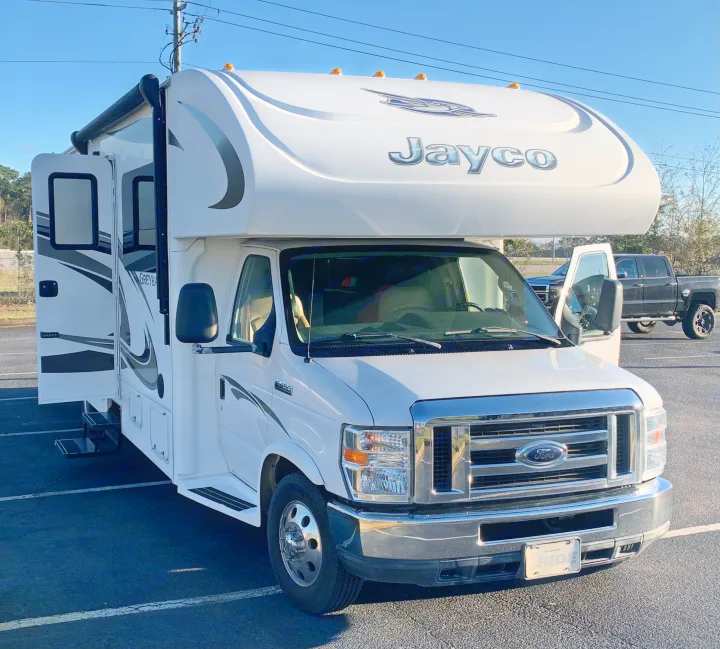 White Jayco Class C RV rental, a Ford motorhome, parked with doors open. Ready for adventure!. Jayco Greyhawk 2014