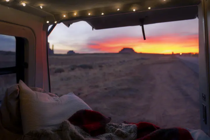 Cozy RV rental interior with string lights overlooking a vibrant desert sunset & landscape. Perfect for travel adventures.. Volkswagen Eurovan Full Camper 2001