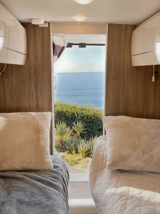 Experience an rv rental with breathtaking ocean views from comfortable beds, surrounded by lush coastal foliage.. Thor Other 2023