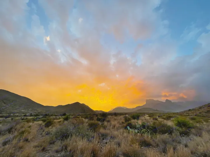 Vibrant sunset paints the desert sky orange and blue over silhouetted mountains; ideal scene for an RV rental escape.. Schutt XV-3 Severe Duty 2022