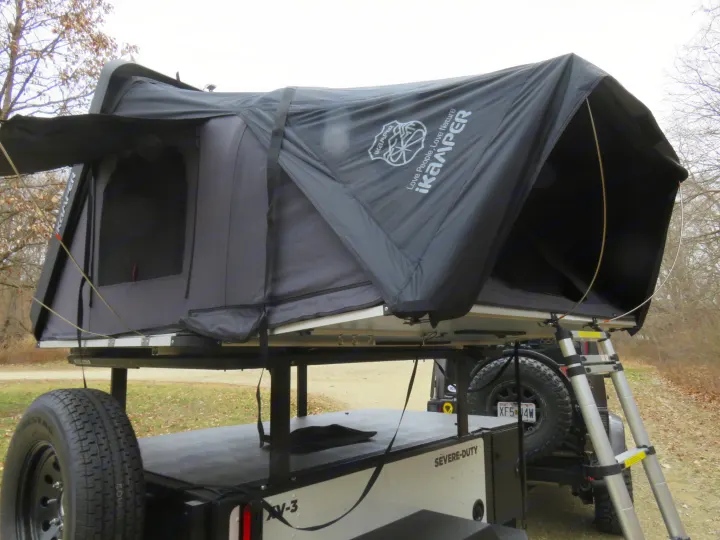 Black iKamper rooftop tent on a camping trailer with ladder, great for your next RV rental outdoor adventure.. Schutt XV-3 Severe Duty 2022
