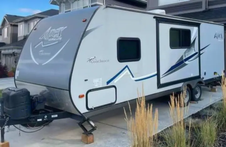 Light gray travel trailer, Coachmen Apex Ultra-Lite model, parked on a driveway, ready for RV rental adventures and camping.. Coachmen Apex LE 2018