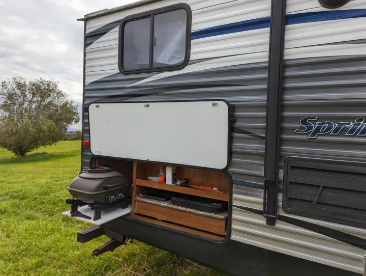 This rv rental showcases a built-in outdoor kitchen, complete with a pull-out grill and storage for camping supplies.. Keystone RV Springdale Eco-Lite 2016