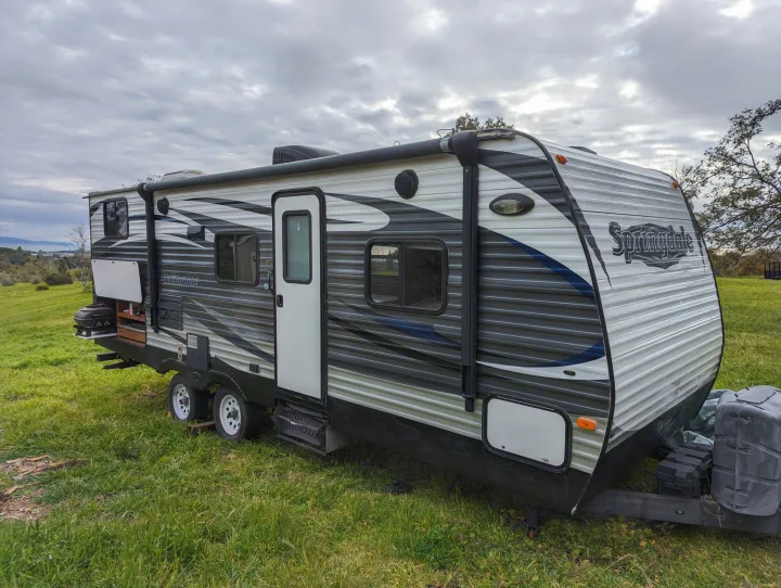 Springdale travel trailer RV rental on a grassy hill with bay views under cloudy skies.. Keystone RV Springdale Eco-Lite 2016