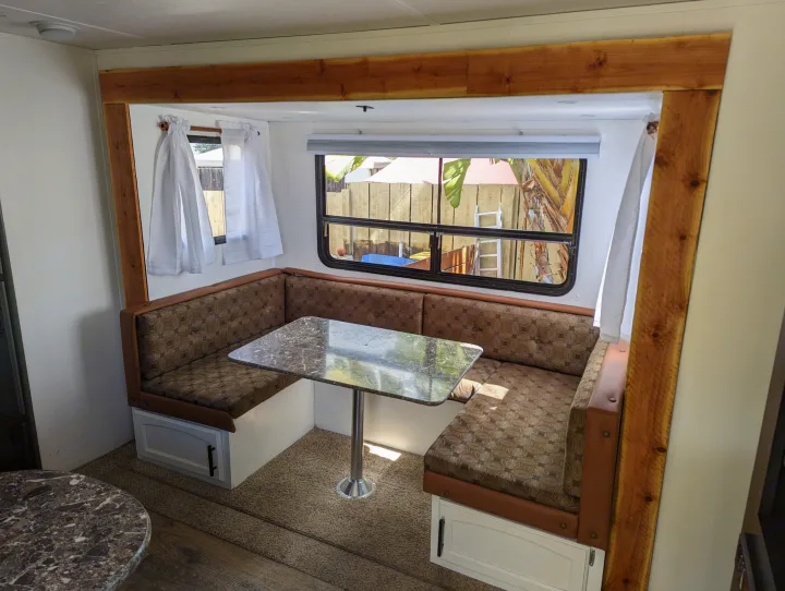 Comfortable RV rental interior featuring a U-shaped dinette, patterned cushions, and a marble-look table.. Keystone RV Springdale Eco-Lite 2016